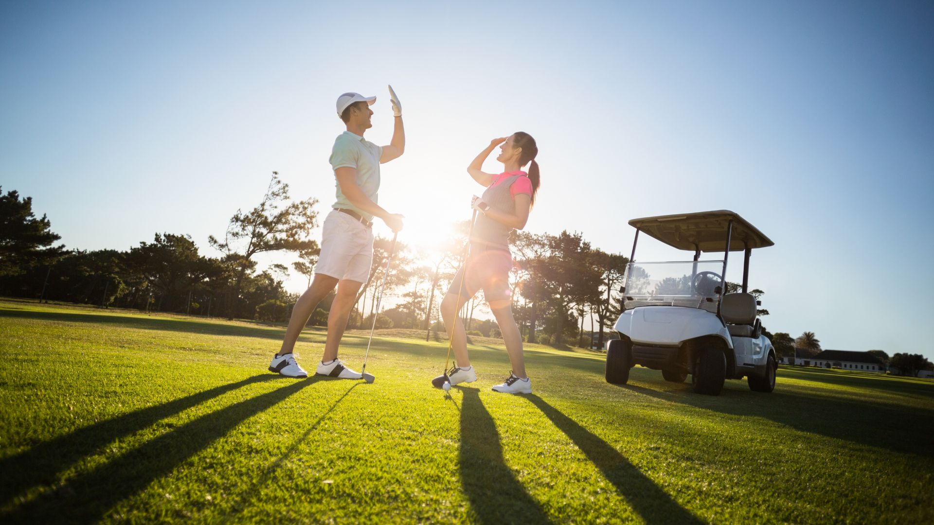 View of couple giving high-five on a golf course